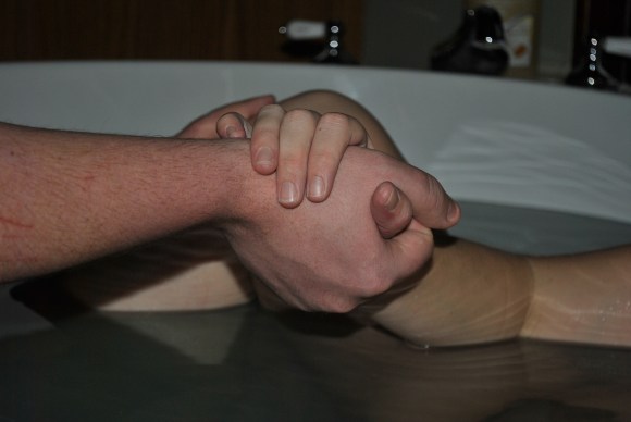 clasped hands of husband and wife
